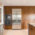 Merit Kitchens two-tone walnut cabinetry. Floor to ceiling cabinets with built-in appliances.