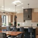 Dining and kitchen integration with quartz island, slab cabinetry, stainless steel appliances, and open layout for family living