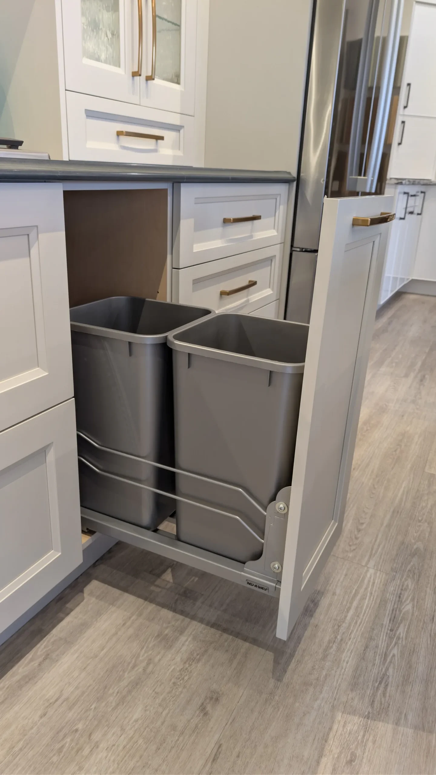 Concealed pull-out garbage and recycling cabinet in a modern kitchen